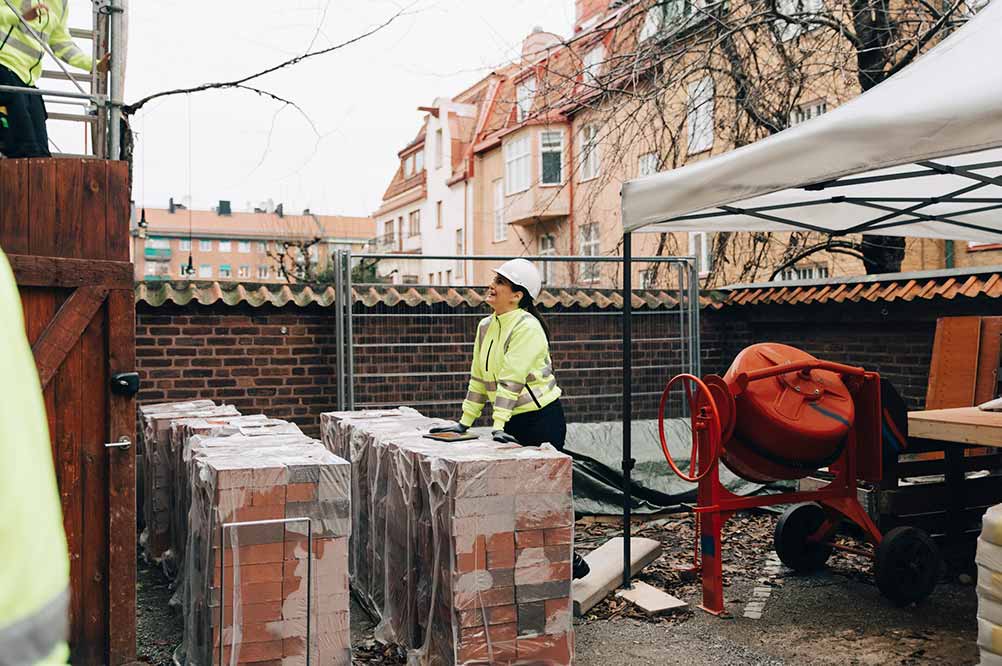 Byggarbetare står vid tegelstenar