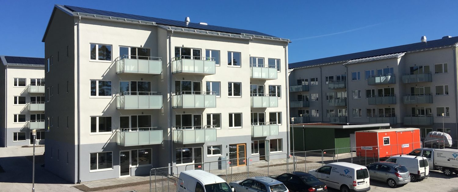 Ett ljusgrönt bostadshus med balkonger