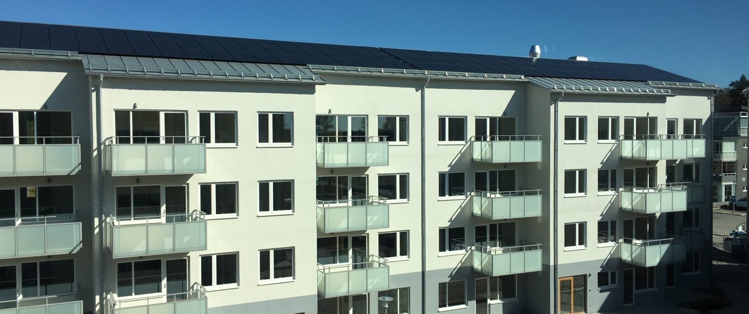 Ett ljusgrönt bostadshus med balkonger